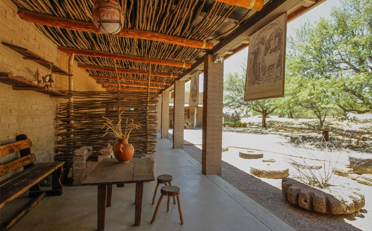 Re-creation of a historic outdoor covered patio with a mesquite branch roof, pottery and stonework planters in the yard