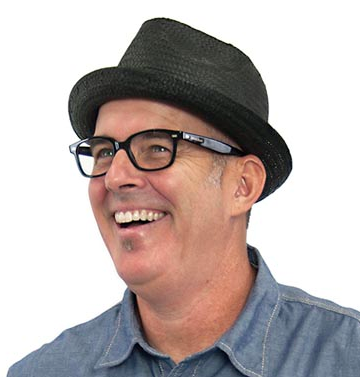 Headshot of a man with thick black glasses and wearing a black fedora
